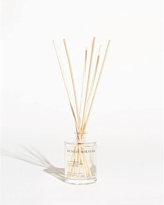 Close-up of the elegant glass diffuser bottle filled with scented oil and natural rattan reeds.