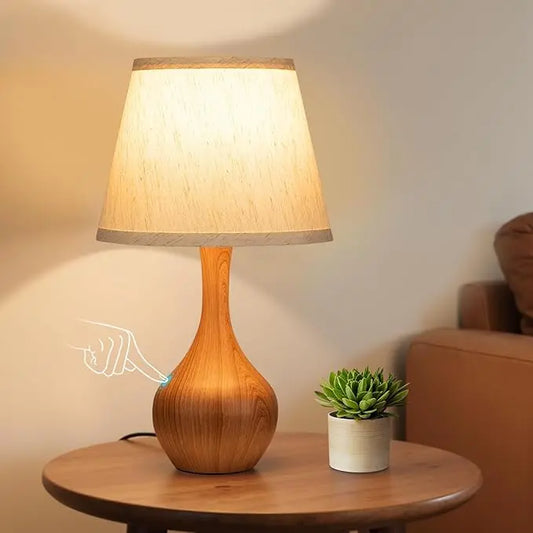 Close-up of the wood table lamp, showcasing its natural texture and touch-activated base.