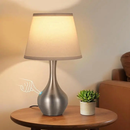 Close-up of the silver table lamp, showcasing its modern design and responsive touch base.