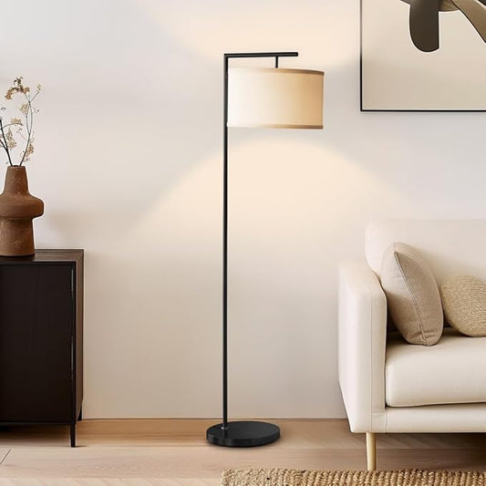 The Brightech Montage Modern lamp illuminating a living room, highlighting its sleek black finish and warm light.