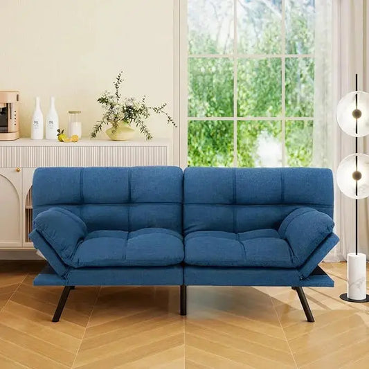 The convertible futon sofa bed in a living room, showcasing its modern design and blue linen upholstery.
