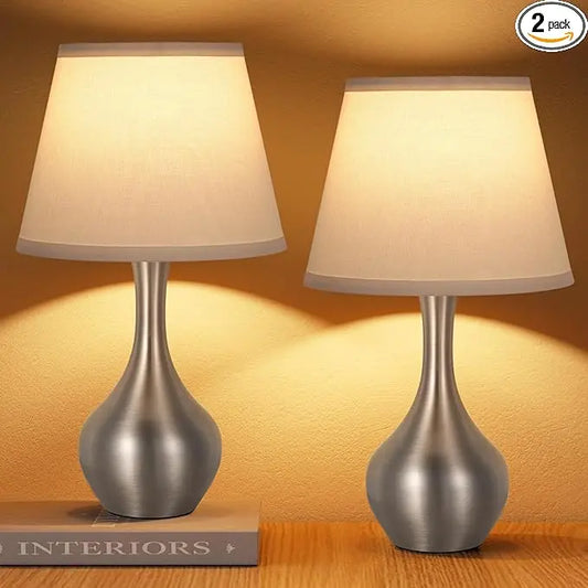 A single silver table lamp, highlighting its contemporary design and touch-activated base.