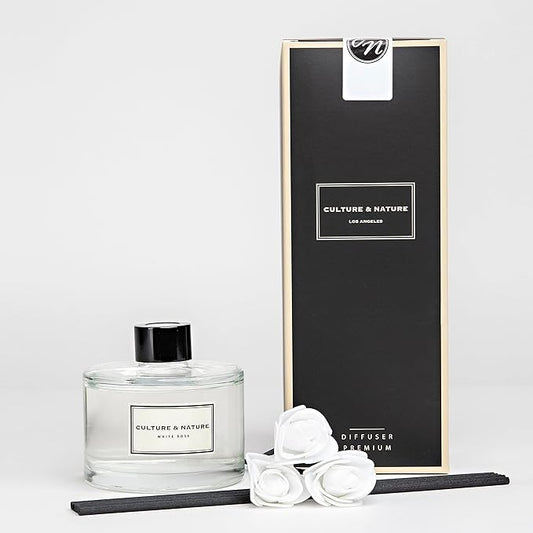 Close-up of the reed diffuser bottle, showing the white rose label and natural reed sticks.