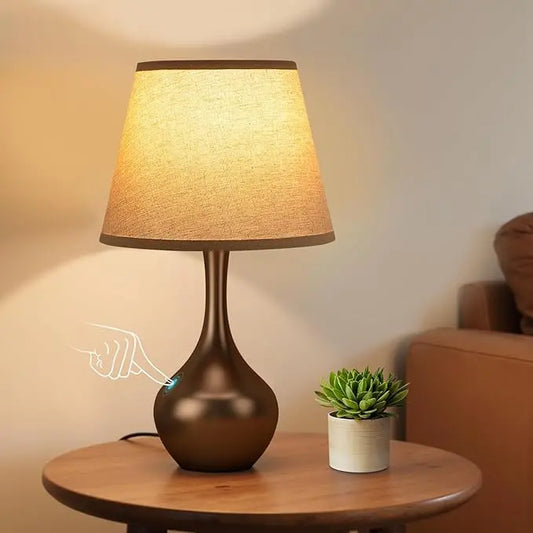 Close-up of the brown table lamp, highlighting its sleek design and touch-sensitive base.