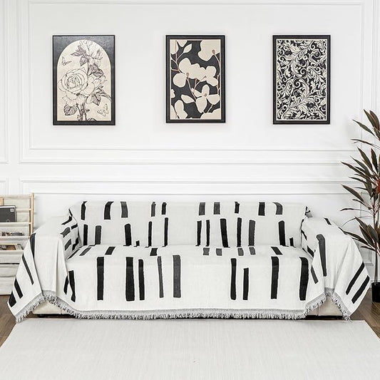 Close-up of the soft, washable chenille fabric, highlighting the black piano key design and tassel detail.