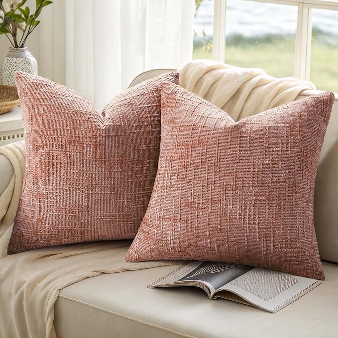 Pink chenille throw pillow cover styled with complementary decor on a living room armchair.