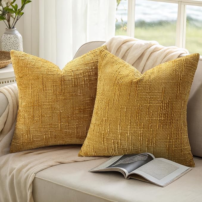Mustard yellow chenille throw pillow cover styled with complementary decor on a living room armchair.