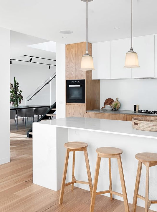 Close-up of the single white glass shade and the brushed nickel hardware of the pendant fixture.
