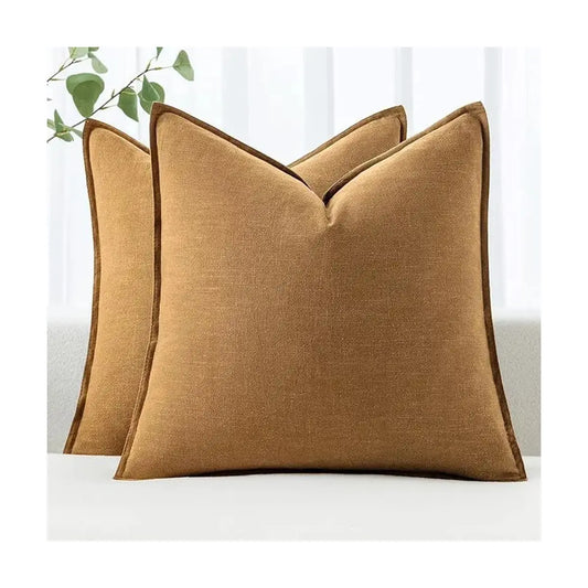 Two hazel pillow covers arranged decoratively on a neutral-toned sofa in a modern living room setting.
