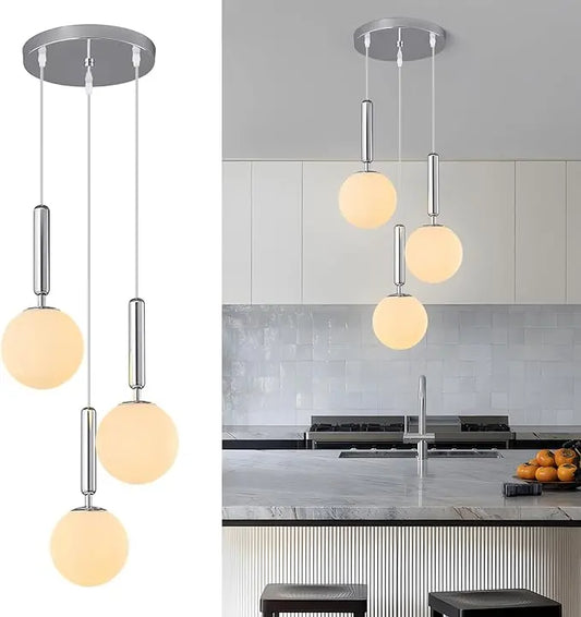 A modern chrome pendant light fixture with three globe-shaped milk white glass shades, hanging.