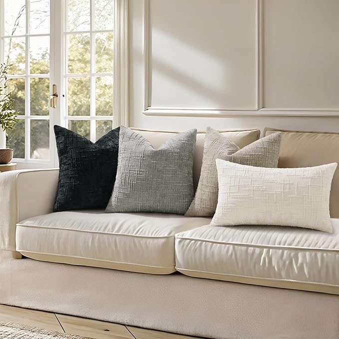 Modern neutral living room featuring black chenille throw pillow covers on a light couch.