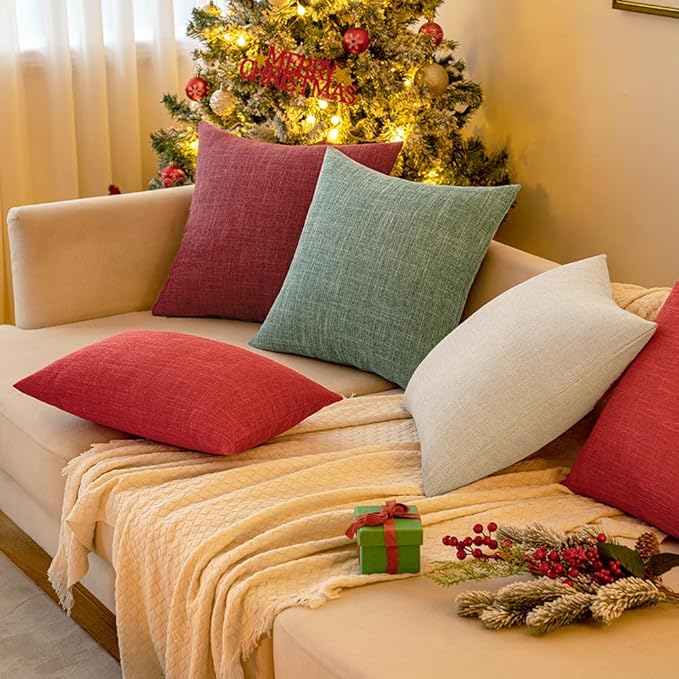 A pair of sage green linen burlap pillow covers arranged artfully on a bench.