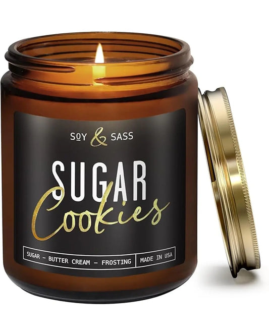 A lit Sugar Cookie scented soy candle in a clear glass jar, with a festive holiday background.