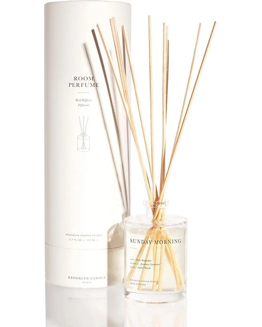 Reed diffuser set with bottle, oil, and 8 rattan reeds arranged on a clean, light-colored surface.