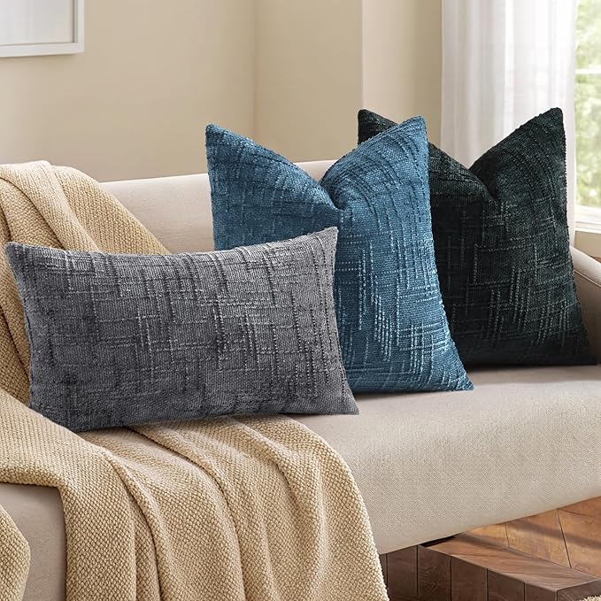 Detail of the hidden zipper closure on the edge of a black slubby chenille pillow cover.