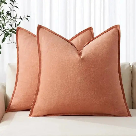 Two coral linen euro sham pillow covers artfully placed on a couch for a pop of color.