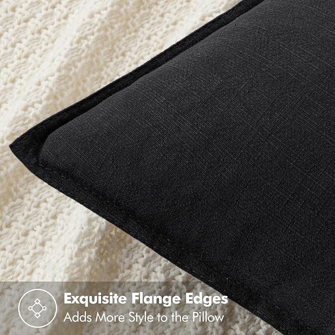A pair of black pillow covers displayed neatly folded on a bed, suitable for Halloween decor.