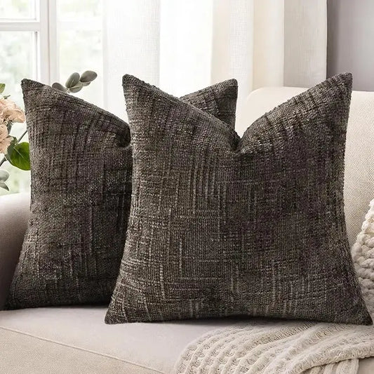 Two 20x20 inch dark brown chenille throw pillow covers arranged on a modern neutral bed or couch.