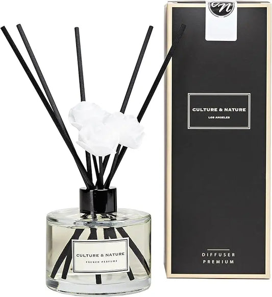 Clear glass reed diffuser bottle with French perfume scented oil and black diffuser sticks.