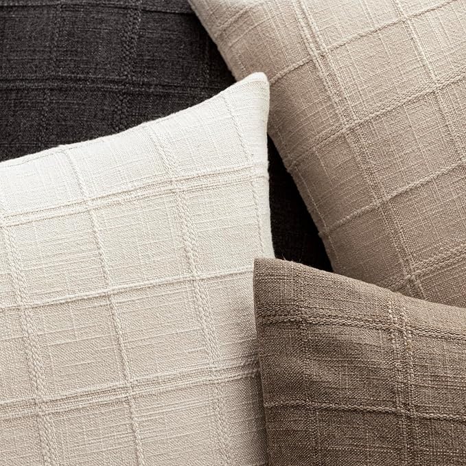 One natural linen check throw pillow cover, neatly folded to showcase the fabric and finished edges.