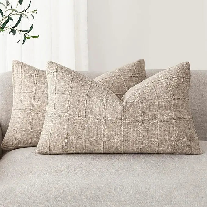 Two natural linen check lumbar pillow covers arranged on a light-colored sofa in a cozy living room.