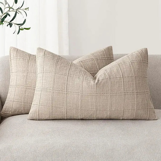 Two natural linen check lumbar pillow covers arranged on a light-colored sofa in a cozy living room.
