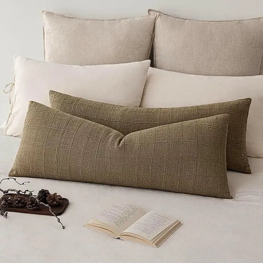 Two light brown linen check lumbar pillows styled on a sofa in a bright, modern farmhouse living room.