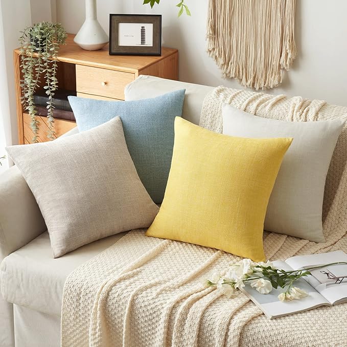 Stack of two neatly folded yellow pillow covers, showcasing their material.