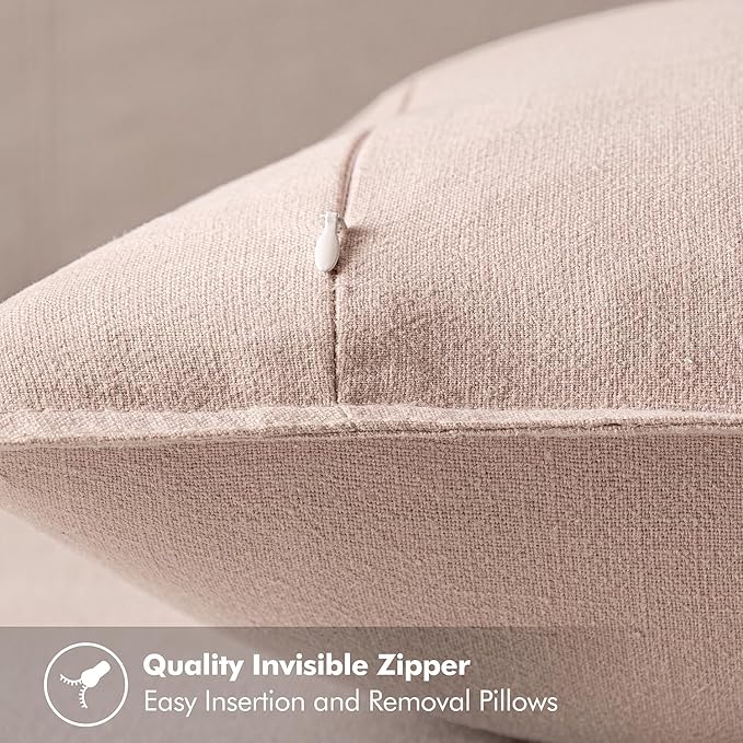 Pair of light pink decorative pillow covers neatly folded, highlighting their gentle hue.