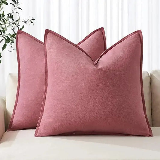 Two cranberry red linen throw pillow covers on a light sofa, adding a bold, modern accent.