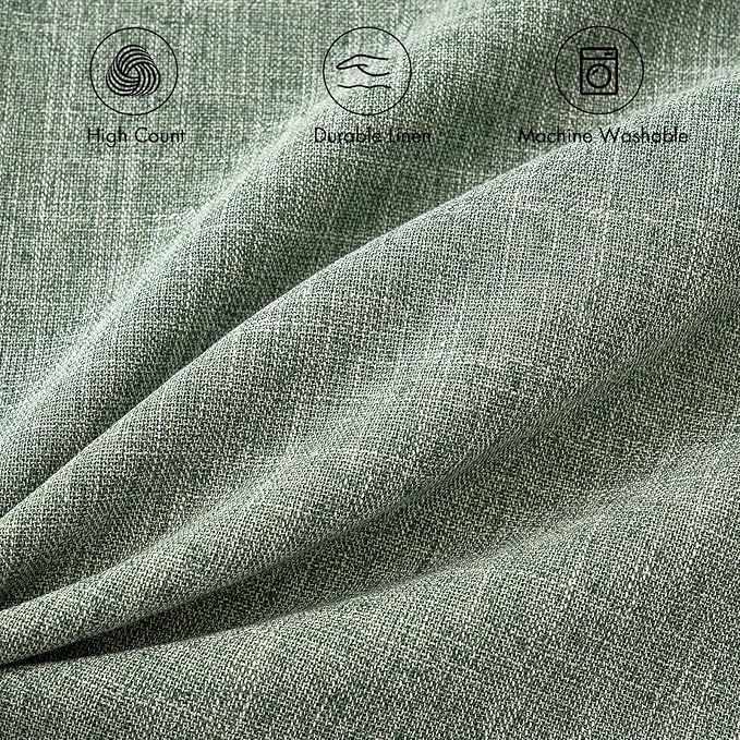 Two sage green decorative pillow covers stacked, showcasing their soft hue.