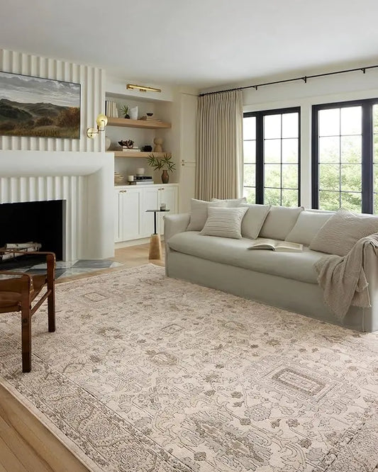 Full view of a high-traffic 7'11" x 10'6" ivory and sand area rug in a large living room.