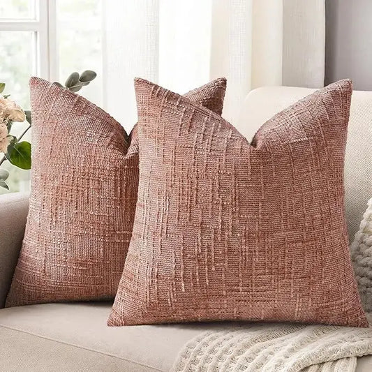 A pair of pink chenille throw pillow covers, 24x24 inches, with a thick textured slubby finish, on a couch.